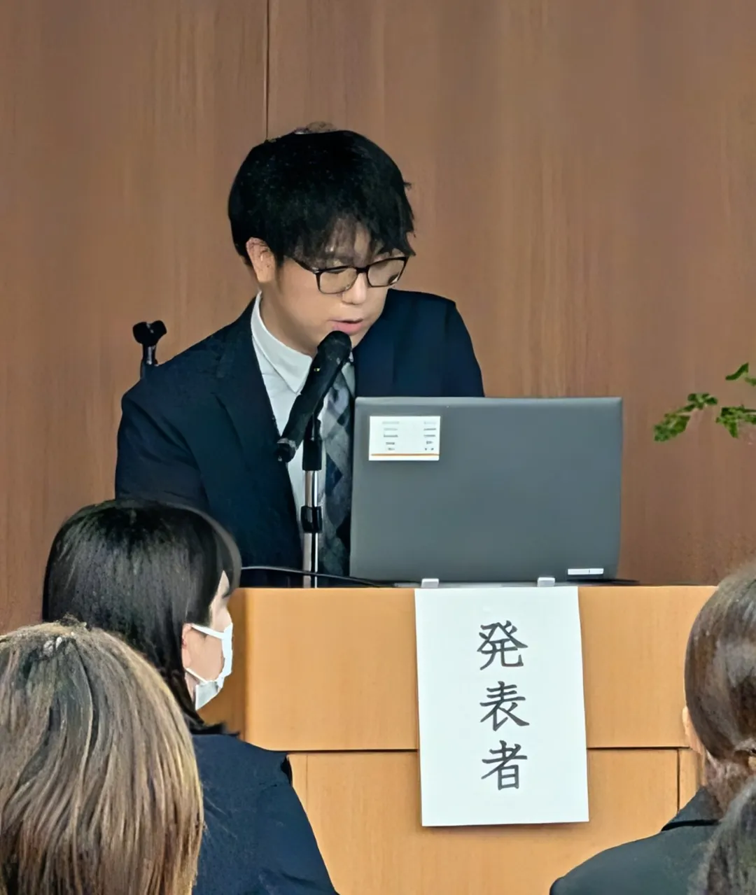 第23回北海道東北地区国立病院機構・国立療養所看護研究学会の壇上でPCを操作しながら発表を行う認定看護師