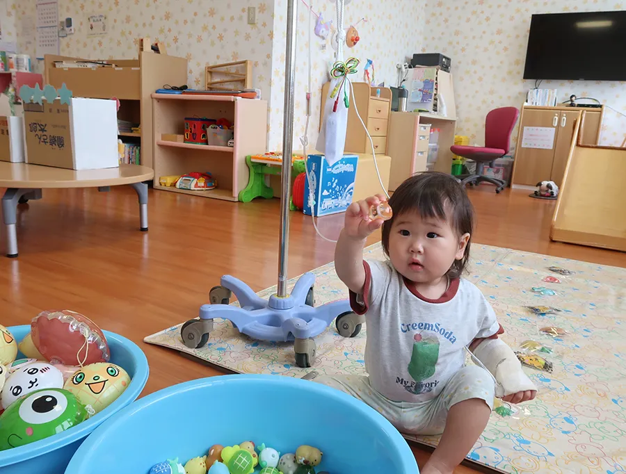 欲しいおもちゃをたらいから選んで嬉しそうにする小さい子